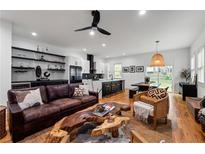 Open concept living room featuring hardwood floors, stylish decor, and kitchen with modern finishes at 210 Locust Ne St, Atlanta, GA 30317
