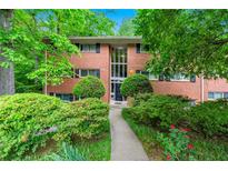 Charming brick apartment building surrounded by lush greenery and a well-maintained landscape at 1111 Clairemont Ave # J6, Decatur, GA 30030