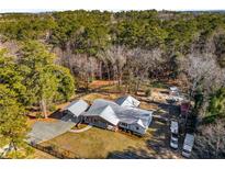 Expansive aerial view of property featuring the house, carport, and surrounding wooded acreage at 5035 Villa Rica Hwy, Dallas, GA 30157