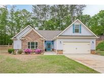 Charming single-Gathering home featuring a stone facade and well-manicured lawn at 549 Greenridge Ln, Loganville, GA 30052