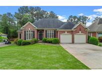 Brick home with a well-manicured lawn, two-car garage, and mature landscaping at 5510 Conway Dr, Marietta, GA 30068