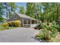 Charming gray home with a welcoming white porch and lush landscaping in a serene setting at 2240 E Lake Ne Dr, Conyers, GA 30012