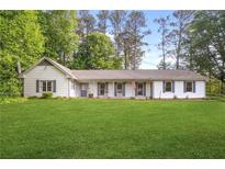 Charming single-story home with white siding, shutters, and a spacious front lawn at 3917 Plantation Dr, Marietta, GA 30062