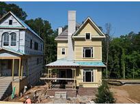 New construction of a charming three-story home with a gray chimney and dark trim windows at 11821 Serenbe Ln, Chattahoochee Hills, GA 30268