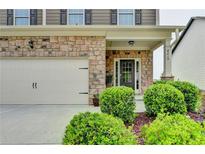 Inviting front entrance with stone accents, well-manicured bushes, and a convenient attached garage at 4215 Cordova Ln, Cumming, GA 30028