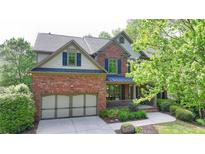 Charming two-story brick home featuring a well-manicured lawn and attached two-car garage at 2725 Monet Dr, Cumming, GA 30041