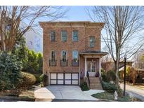 Brick home featuring a two-car garage, small front porch, and multiple stories at 540 Woodall Ne Ave, Atlanta, GA 30306