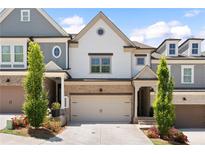 Charming exterior of a two-story home with brick accents, a two-car garage and manicured landscaping at 409 Retreat Ln, Canton, GA 30114