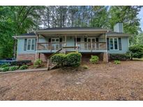 Charming single-story home with a welcoming front porch and mature trees at 5873 Trellis Ct, Powder Springs, GA 30127