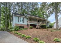 Charming home featuring brick accents, a cozy front porch, and a well-manicured lawn at 5873 Trellis Ct, Powder Springs, GA 30127
