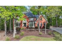 Beautiful two-story brick home with a manicured lawn and mature trees providing privacy and shade at 2975 Coles Way, Atlanta, GA 30350