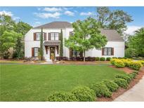 Charming two-story home featuring a well-manicured lawn, tasteful landscaping, and traditional white siding with dark shutters at 3920 Cash Lndg, Marietta, GA 30066
