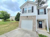 Charming two-story home with gray siding, brick accents, a single car garage, and a well-manicured lawn at 2365 Hackamore Dr, Atlanta, GA 30349