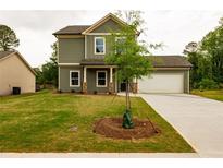 Two-story home with green siding, a well-kept lawn, covered porch, and attached two car garage at 358 Forkview Dr, Lawrenceville, GA 30044