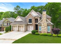Beautiful brick home features a three-car garage, manicured lawn, and stone chimney at 5826 Sarazen Trl, Douglasville, GA 30135