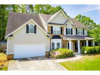 Charming two-story home with a well-manicured lawn, mature trees, and a two-car garage at 210 Creekside Overlook, Hiram, GA 30141
