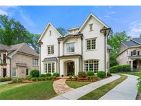 Elegant two-story white brick home featuring a well-manicured lawn, stone walkway, and a concrete driveway at 4005 N Stratford Ne Rd, Atlanta, GA 30342