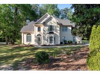 Charming two-story home with a well-manicured lawn and mature trees at 120 Julia Ct, Fayetteville, GA 30214