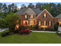 Charming two-story brick home with a well-manicured lawn, beautiful landscaping, and inviting curb appeal at 2439 Huntington Park Nw Dr, Acworth, GA 30101