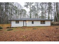 Charming single-story home featuring a white exterior, black trim, and a well-manicured yard at 5101 Rockbridge Rd, Stone Mountain, GA 30088