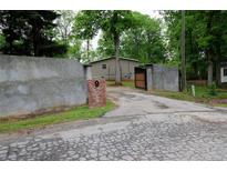 Gated entry with brick mailbox leading to a single story home surrounded by mature trees at 208 Holiday Way, Carrollton, GA 30116