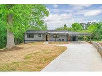 Charming single-story home featuring a long driveway, covered parking, and beautifully landscaped surroundings at 4901 Prince Se Rd, Smyrna, GA 30082