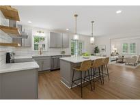 Modern kitchen boasts stainless steel appliances, a center island, and pendant lighting at 2590 Eastwood Dr, Decatur, GA 30032