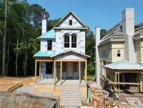 New construction home featuring a classic design, porch and second story arched windows at 11825 Serenbe Ln, Chattahoochee Hills, GA 30268