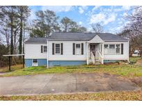 Charming single-story home featuring a driveway, front porch, and light-colored siding at 1496 S Hairston Rd, Stone Mountain, GA 30088