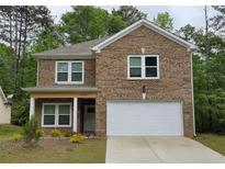 Charming brick two-story home featuring a white two-car garage and a manicured front yard at 3362 Bonnes Ct, Ellenwood, GA 30294