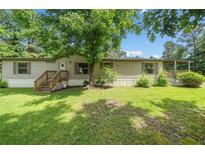 Charming single-story home with a well-maintained lawn, inviting entryway, and a large mature tree providing ample shade at 170 White Rose Ln, Temple, GA 30179