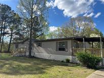 Charming single-story home with a covered porch, complemented by well-maintained landscaping at 170 White Rose Ln, Temple, GA 30179