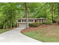 Charming split-level home with brick accents, well-manicured landscaping, and a long driveway at 2488 Fontainebleau Dr, Dunwoody, GA 30360
