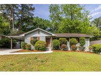 Charming single-story home featuring a well-manicured lawn, inviting curb appeal, and mature trees at 1875 Fairway Ne Cir, Atlanta, GA 30319