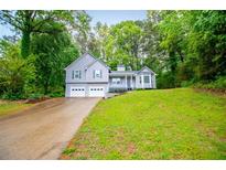 Charming two-story home with a lush green lawn and a two car garage at 4822 Westbourne Dr, Powder Springs, GA 30127
