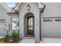 Inviting front entrance with a handsome wood door and brick facade for a touch of timeless elegance at 5128 Noble Village Way # 35, Lilburn, GA 30047