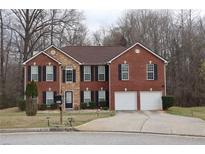 Charming brick two-story home featuring a two-car garage, manicured lawn, and classic architectural details at 8871 Jimmy Lee Cir, Jonesboro, GA 30238
