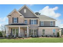 Stunning two-story home with a brick facade, well-manicured lawn, and professional landscaping at 1628 Baytree Dr, Cumming, GA 30040