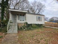 Modest one-story home with mature trees and established landscaping at 1651 Aiken Sw St, Atlanta, GA 30315