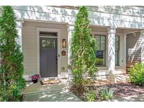 Charming townhome entrance with a stylish gray door, green arborvitae, and a manicured front garden at 175 Stovall Se St, Atlanta, GA 30316