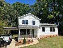 Charming two-story home with white siding, modern windows and a covered carport and manicured front yard at 169 Long Dr, Marietta, GA 30060