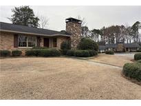Charming brick home with a stone chimney and mature landscaping, offering a classic aesthetic at 3358 Stonecrest Ct, Atlanta, GA 30341