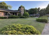 Charming brick home with a stone chimney and well-manicured landscaping in a suburban neighborhood at 3358 Stonecrest Ct, Atlanta, GA 30341