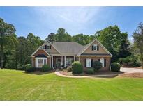 Charming single-story brick home with lush green lawn and manicured landscaping on a sunny day at 5030 Princeton Trce, Cumming, GA 30041