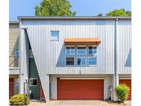 Modern townhome features a metal facade, red garage door, and awning for a contemporary look at 920 Memorial Se Dr # 11, Atlanta, GA 30316