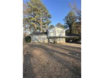 Two-story home with neutral siding, covered carport, and a well-manicured lawn at 1905 Rollingwood Se Dr, Atlanta, GA 30316