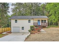 Charming two-story home features a welcoming blue door and a well-maintained front yard with garden at 1213 Anderson Mill Rd, Austell, GA 30106