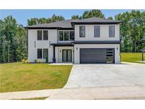 Modern two-story home with a black garage door, black window trim, and a well-manicured lawn at 51 Deer Canyon Dr, Auburn, GA 30011
