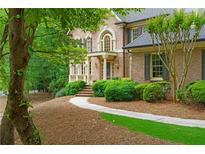 Stately brick home with manicured landscaping and inviting front entrance at 1100 Kensington Ct, Johns Creek, GA 30022