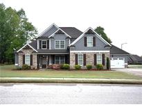 Charming two-story home featuring a stone and siding facade, a well-manicured lawn, and an attached two-car garage at 15 Worthington Dr, Villa Rica, GA 30180